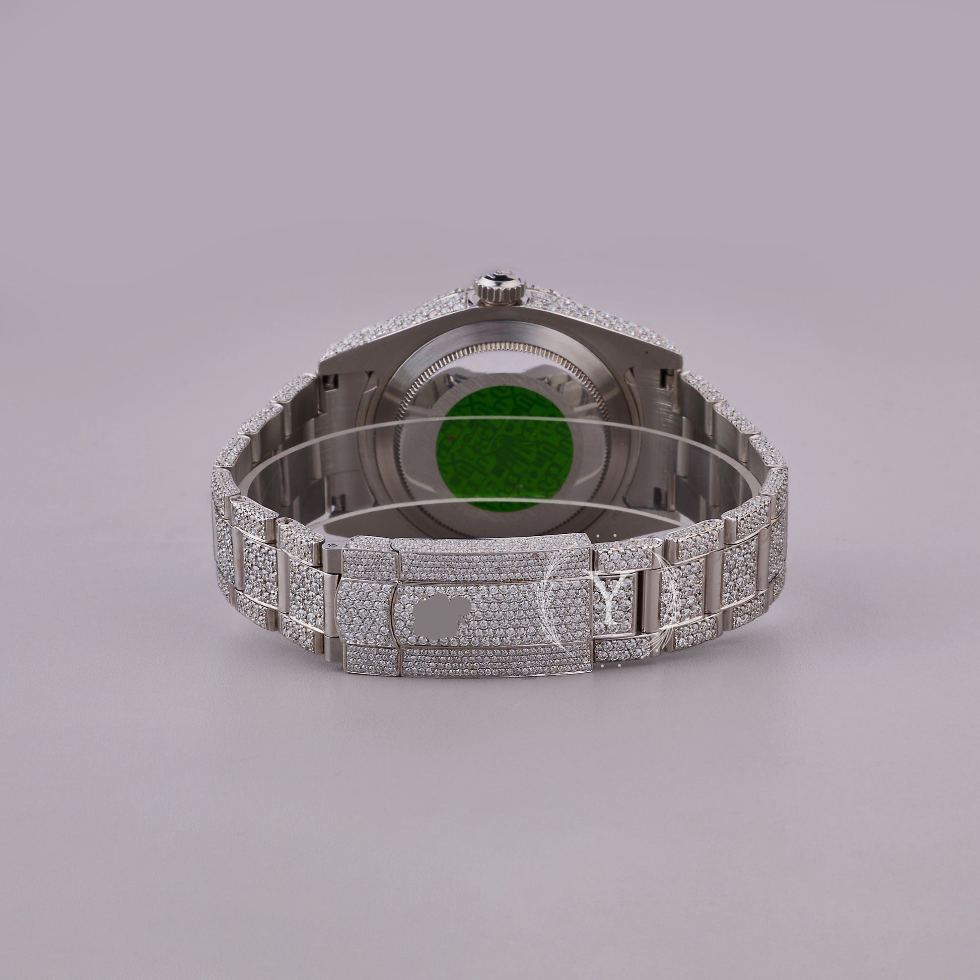 Luxury watch with diamond-studded case and bezel on a gray background