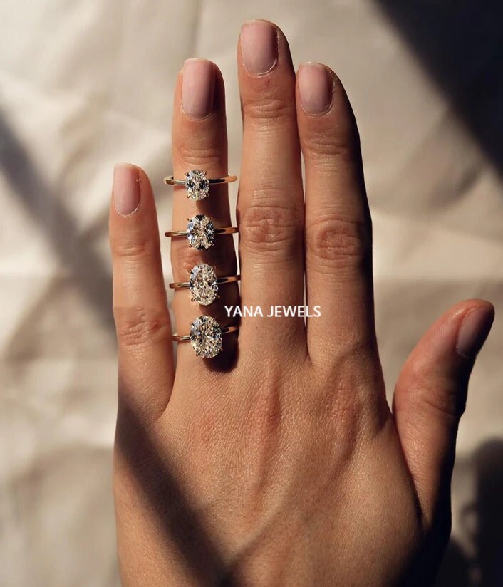 a woman&#39;s hand with three rings on it