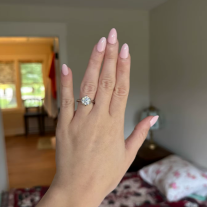Woman's hand showcasing The $99 Diamond Alternative Ring with a sparkling moissanite stone.