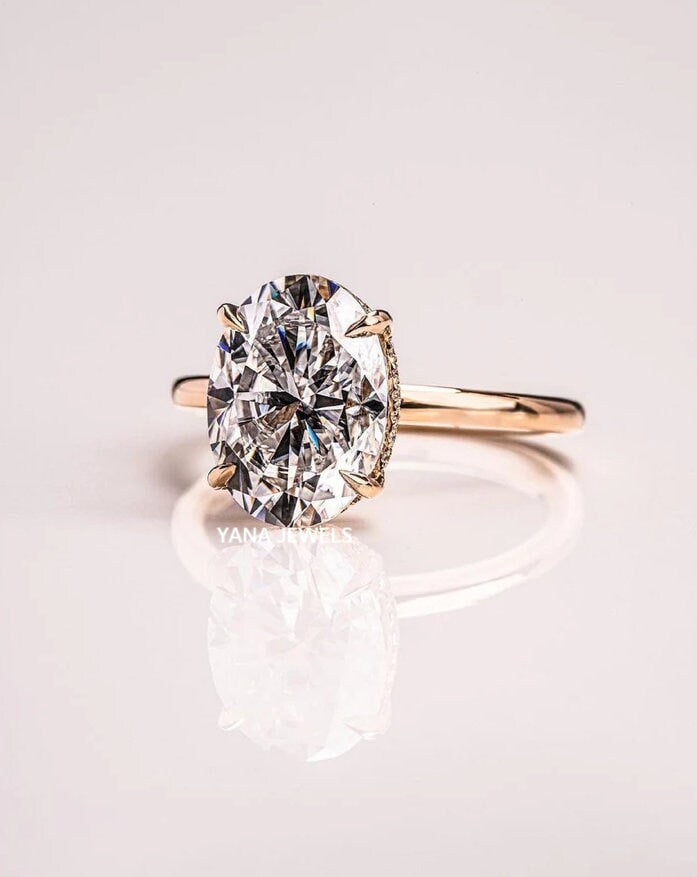a close up of a diamond ring on a white surface